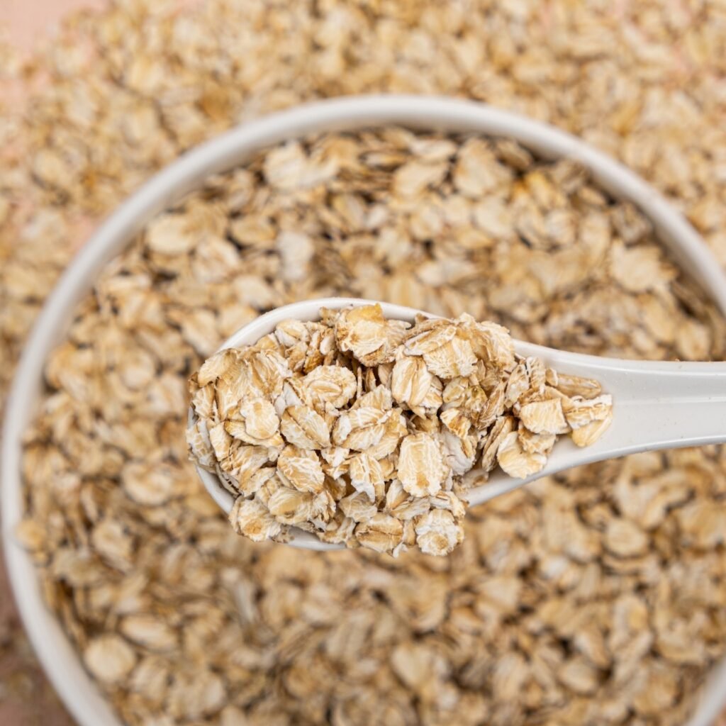 dry,uncooked,oat,flakes,in,a,spoon,top,view